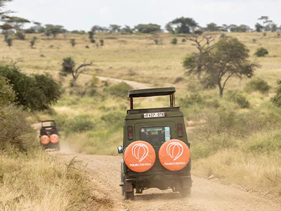 TourCompass safarivoertuig rijdt op de weg in Tanzania