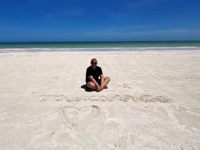 Tom zit in het zand op Isla Holbox in Mexico