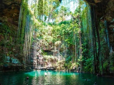 Lichtstralen vallen neer door de Ik Kil-cenote