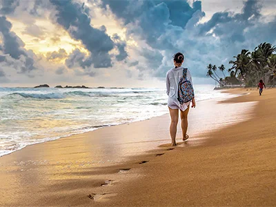 Vrouw wandelt langs het strand in Sri Lanka