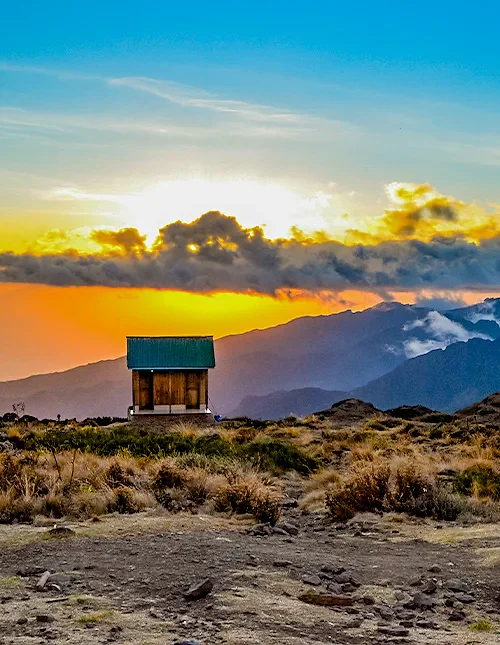 Kleine hut op de hellingen van de Kilimanjaro bij zonsondergang.