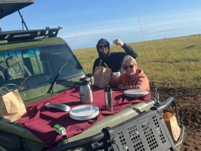 Twee mensen ontbijten op het safarivoertuig