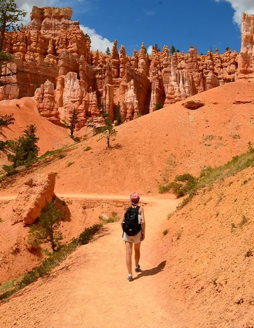 Een persoon loopt over een pad tussen de iconische oranje rotsformaties in het nationaal park Bryce Canyon, Utah, VS.